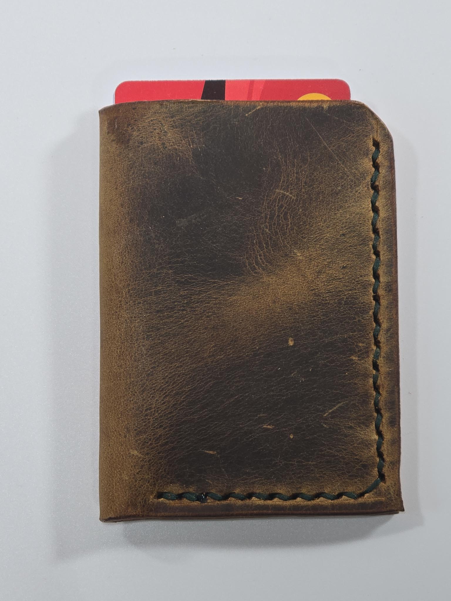 Brown leather wallet with a red card on a white background