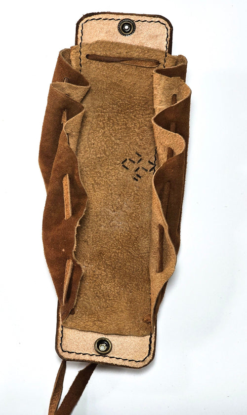 A brown suede or leather pouch with a snap-button closure and a small stitched geometric emblem on the front, shown against a plain white background.