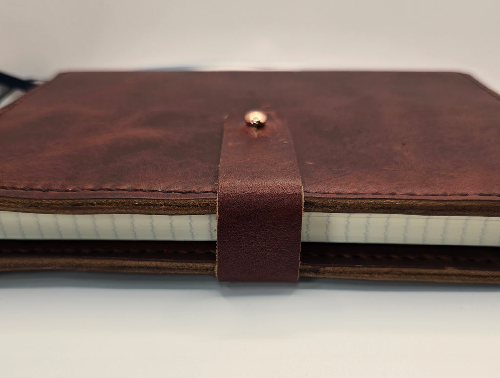 Side view of Burgundy leather journal cover showing stud button closure - Handcrafted A5 leather notebook cover.