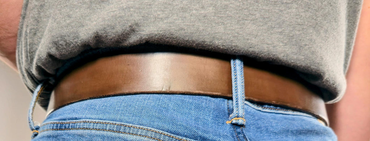 Person wearing the chocolate brown leather belt with blue jeans
