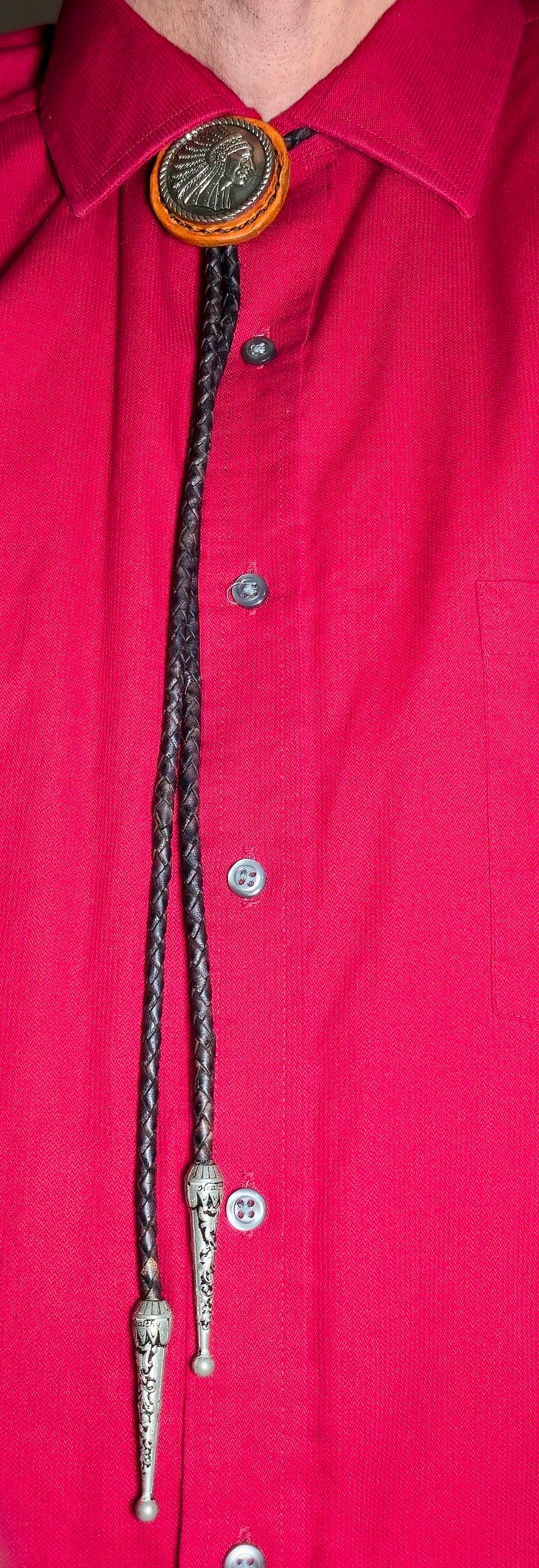 Close-up of a red shirt with a decorative bolo tie.