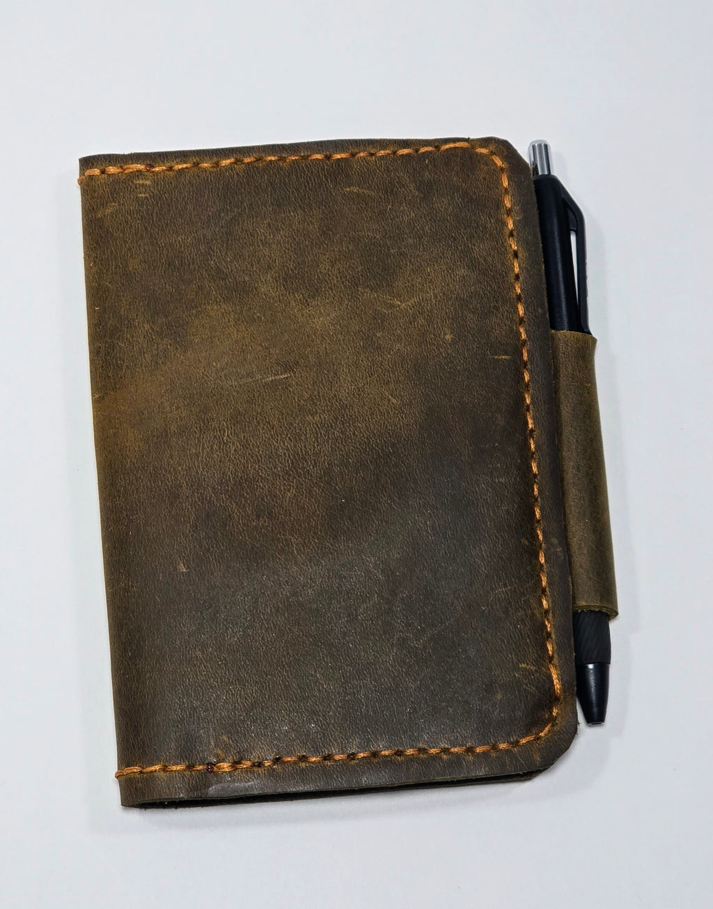 Brown leather notebook with a pen on a white background