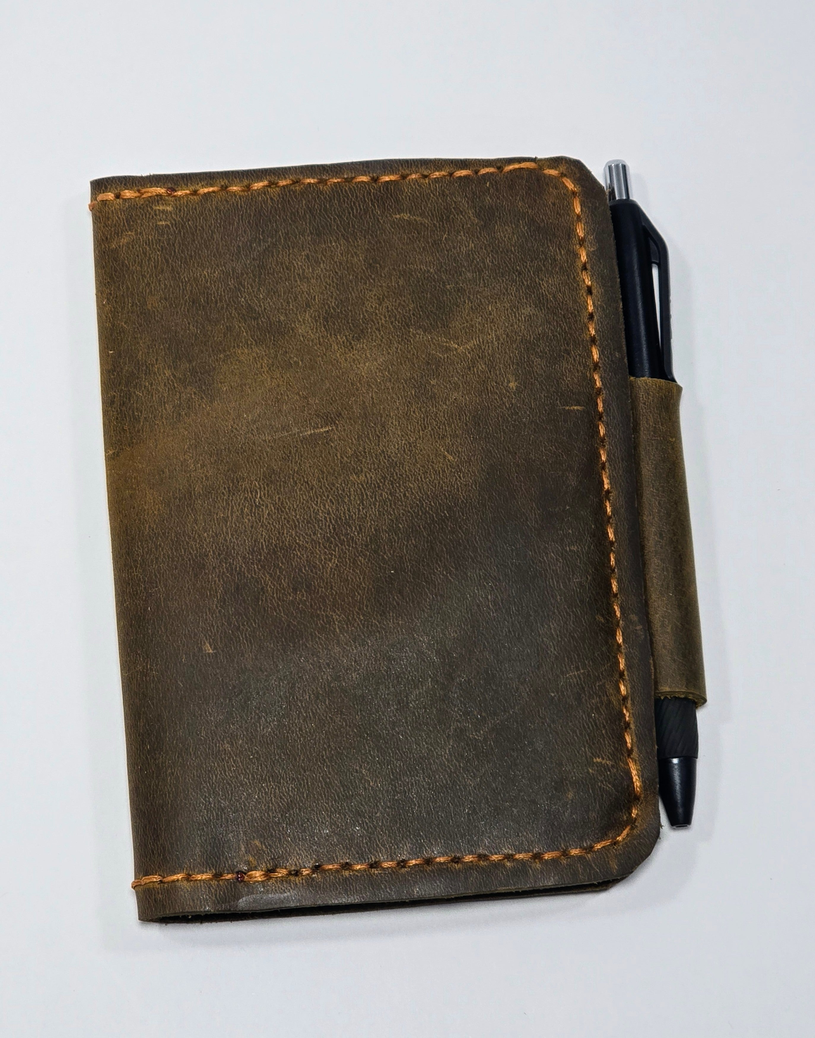 Brown leather notebook with a pen on a white background