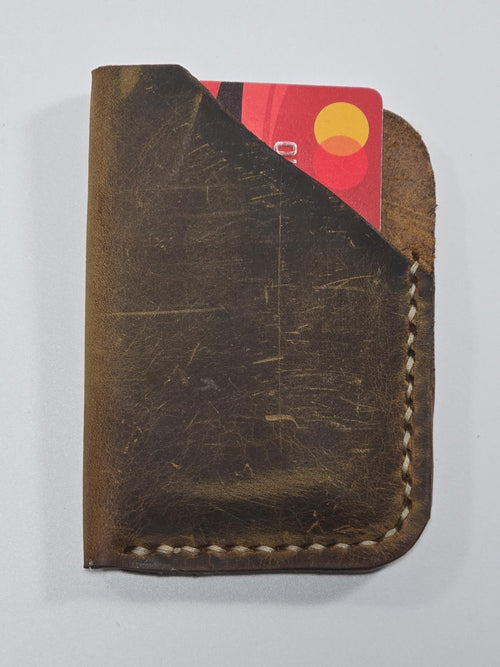 Brown leather wallet with a card peeking out on a white background