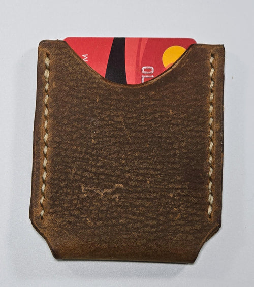 Brown leather cardholder with a red card inside on a white background